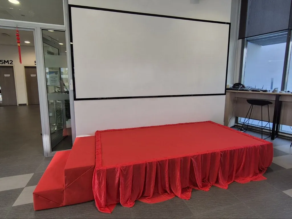 Platform stage with red skirting and red-covered steps in a Singapore function room